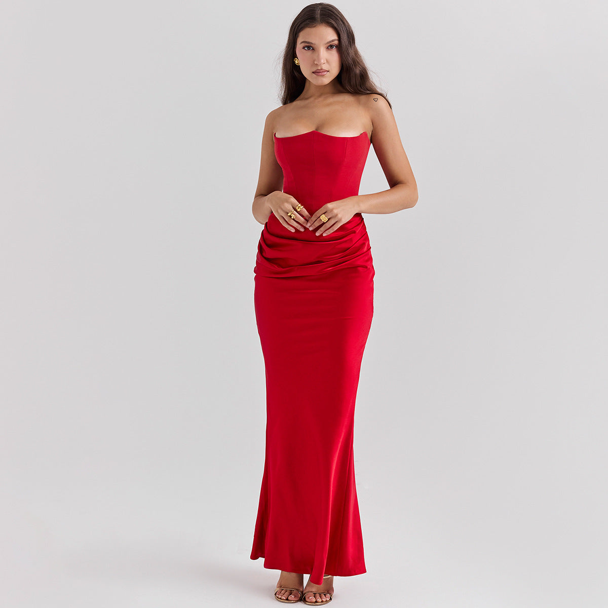 Woman wearing a strapless red dress on a gray background