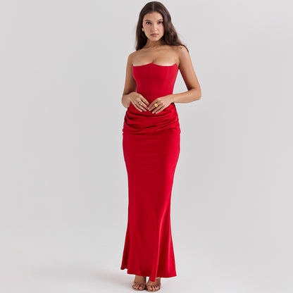Woman wearing a strapless red dress on a gray background