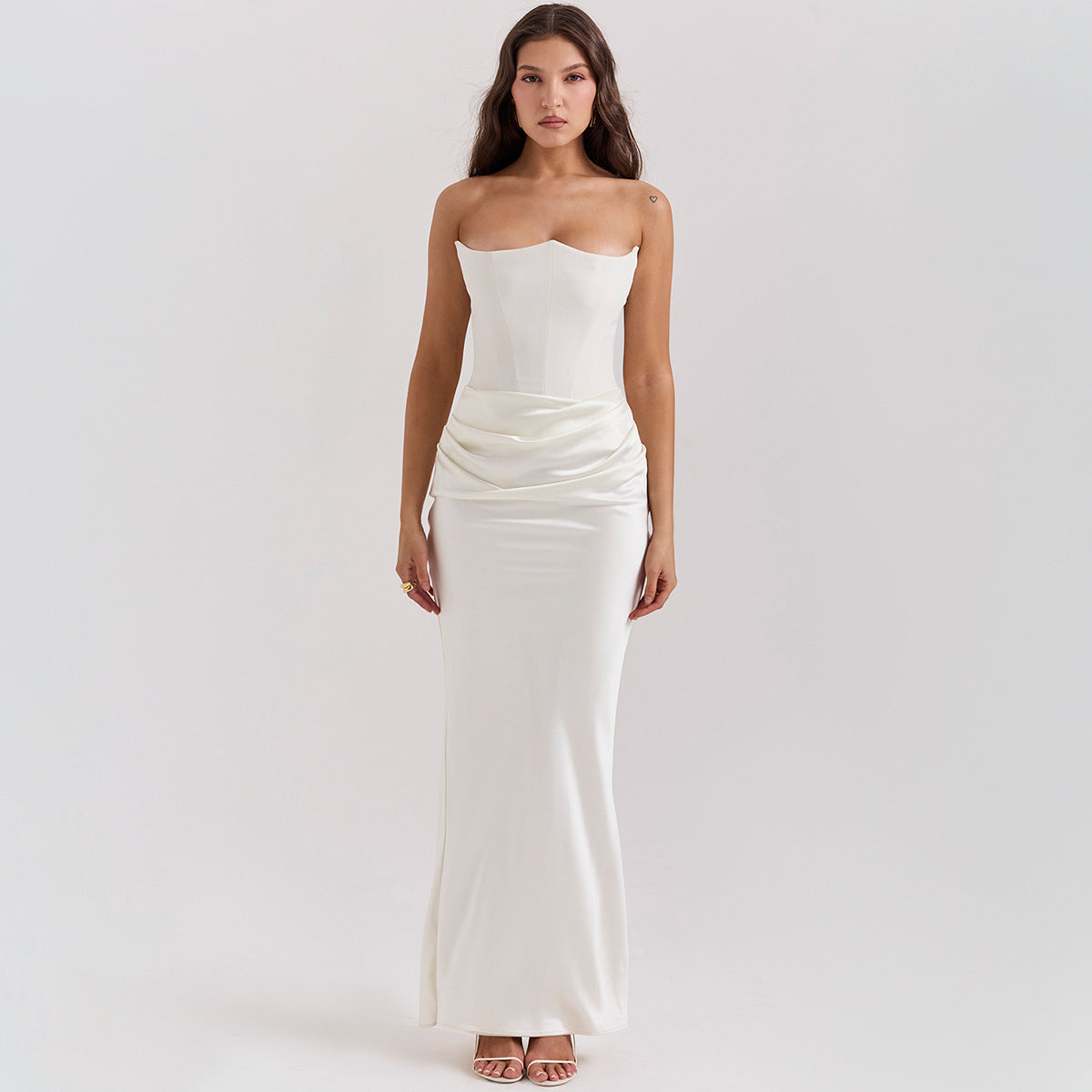 Woman wearing a white strapless gown on a plain background