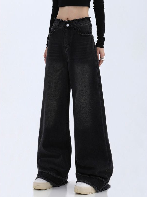 Black wide-leg jeans worn by a person on a white background