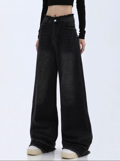 Black wide-leg jeans worn by a person on a white background
