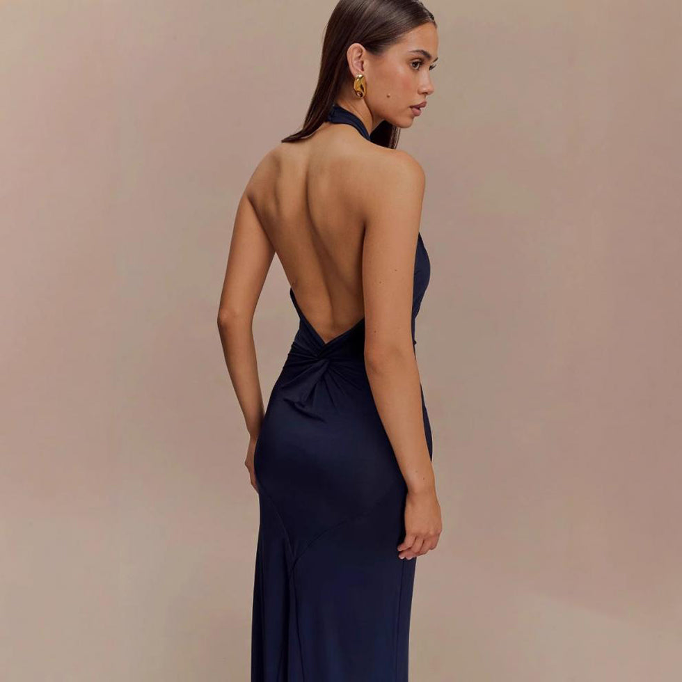 Model wearing a backless halter dress