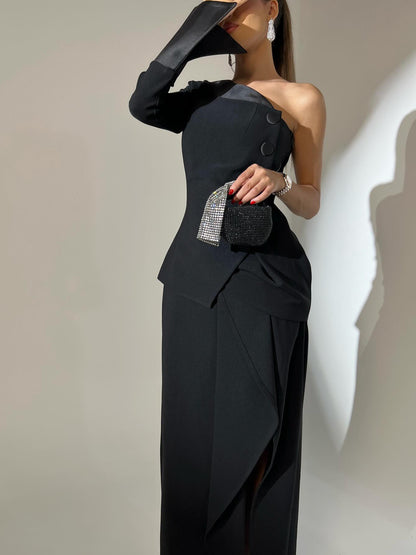 Black one-shoulder dress with a textured panel against a neutral background