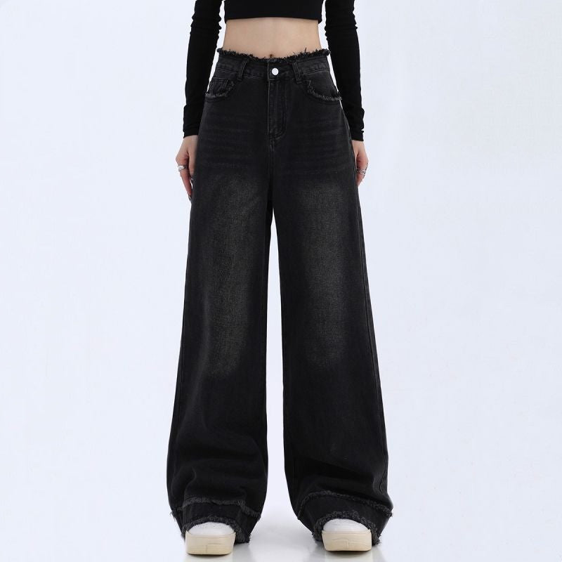 Black wide-leg jeans worn by a person on a white background