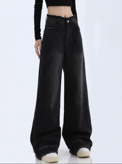 Black wide-leg jeans worn by a person on a white background