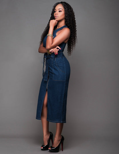 Woman wearing a blue denim dress against a gray background