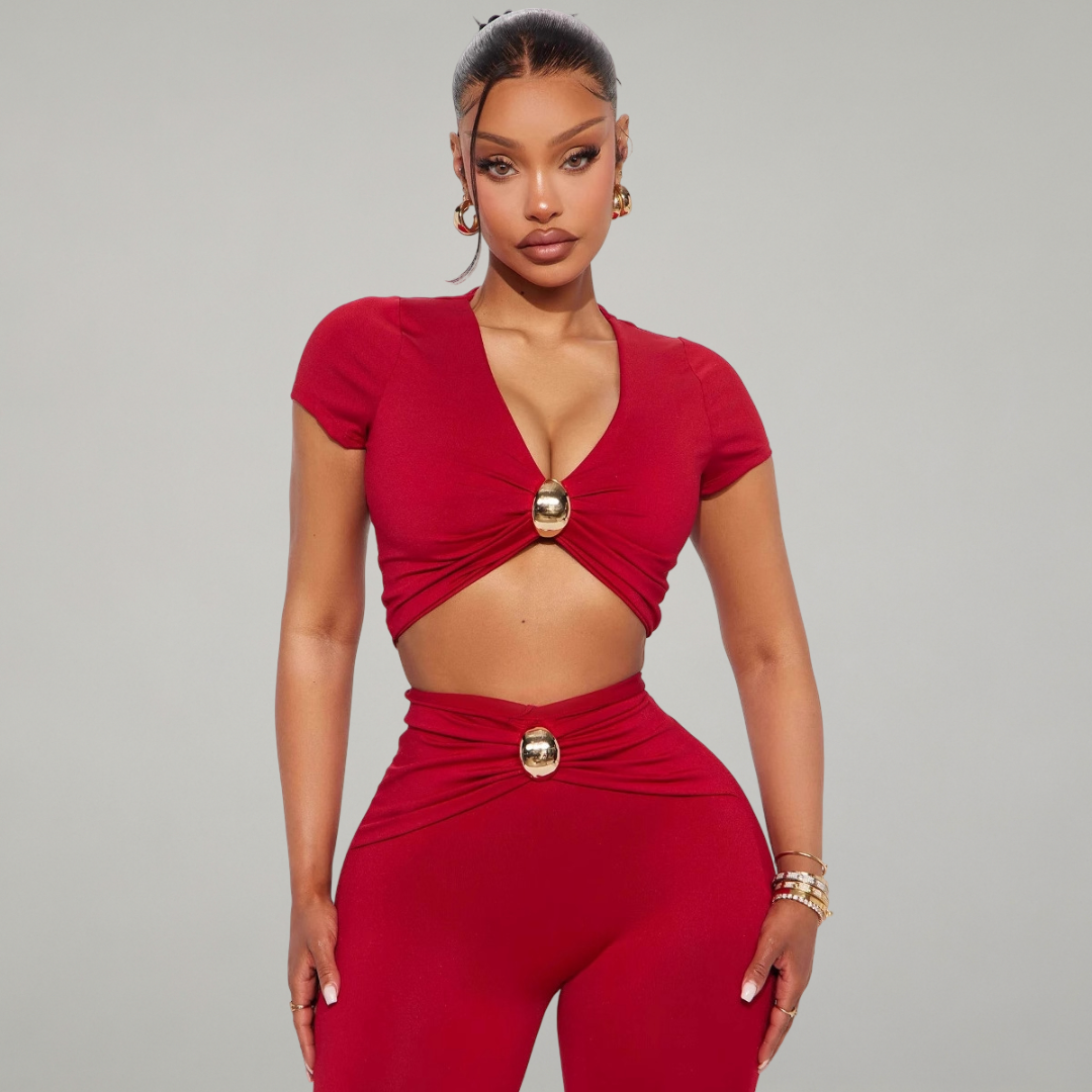 Woman wearing a red outfit with gold accents on a gray background