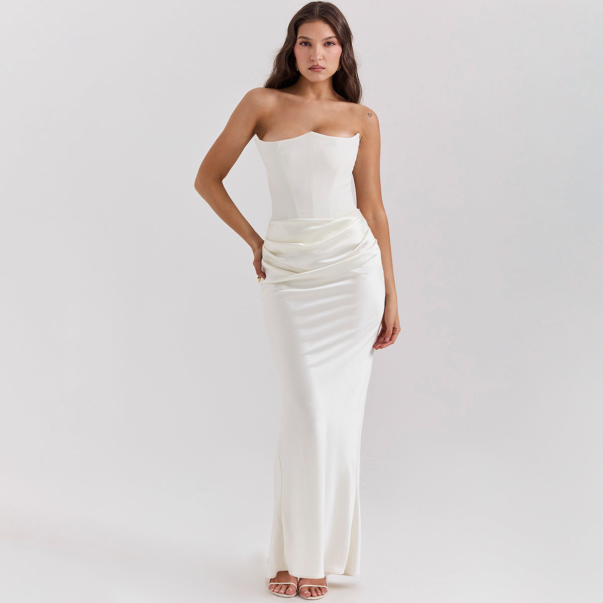 Woman wearing a white strapless gown on a plain background