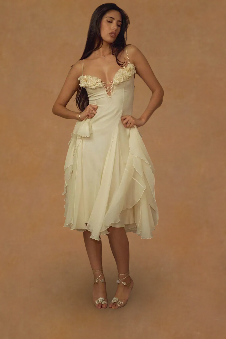 Woman wearing a white dress with lace details against a beige background