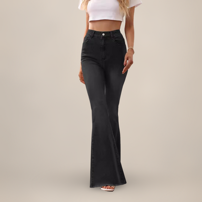 Person wearing black flared jeans on a plain background