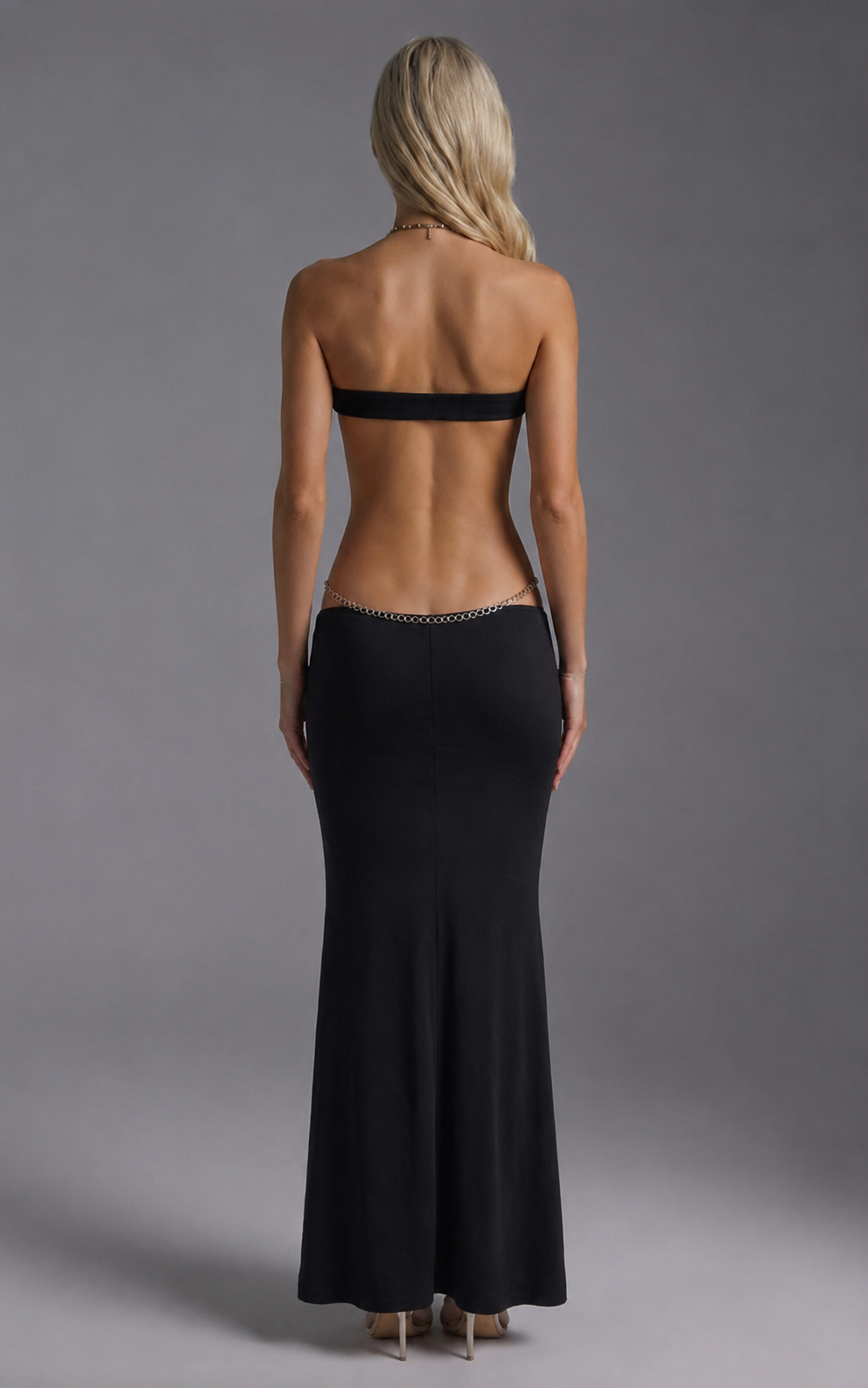 Black strapless backless maxi dress with silver chain detailing and cutout torso
