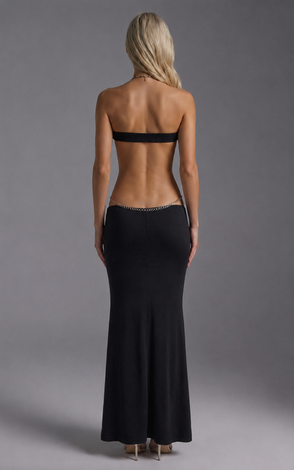 Black strapless backless maxi dress with silver chain detailing and cutout torso
