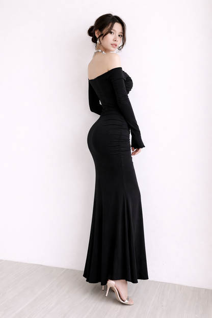 Woman wearing a black off-shoulder gown against a white background