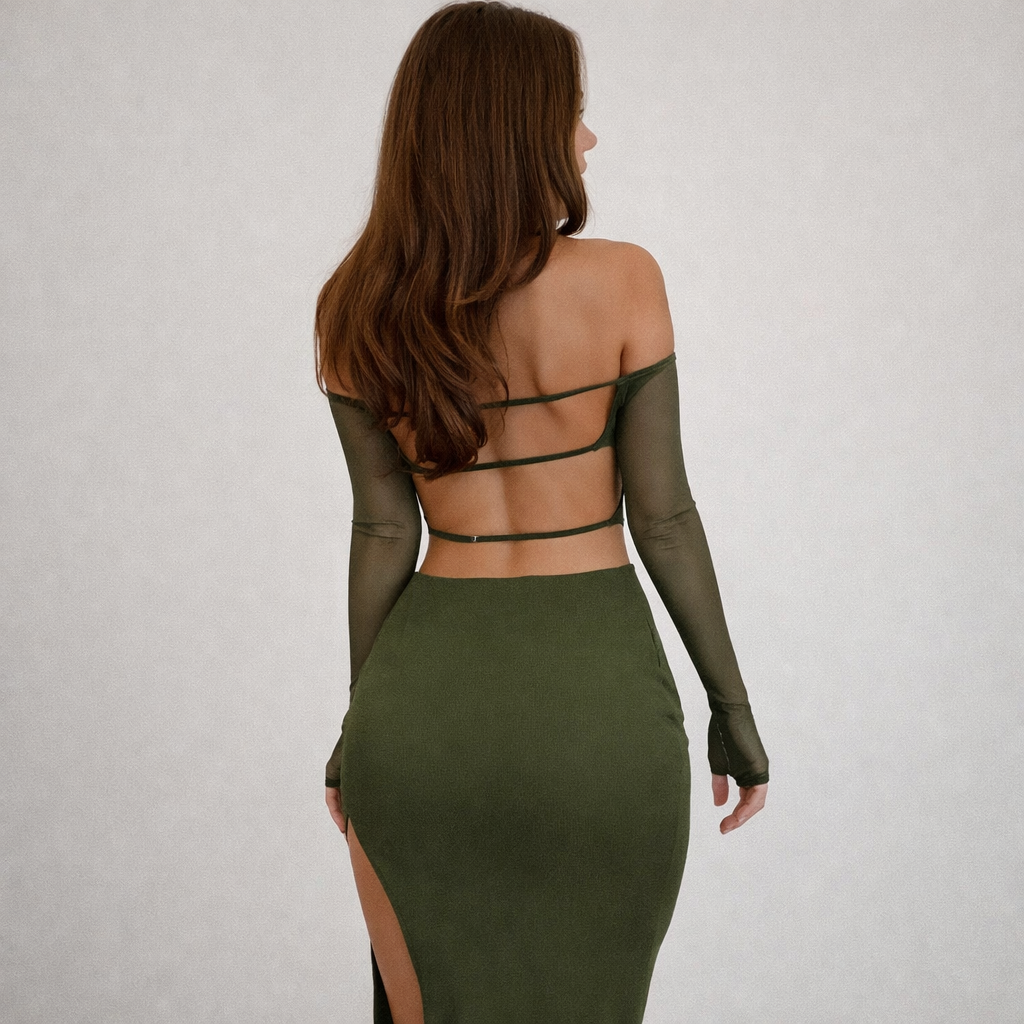 Woman wearing a green dress with mesh sleeves on a plain background