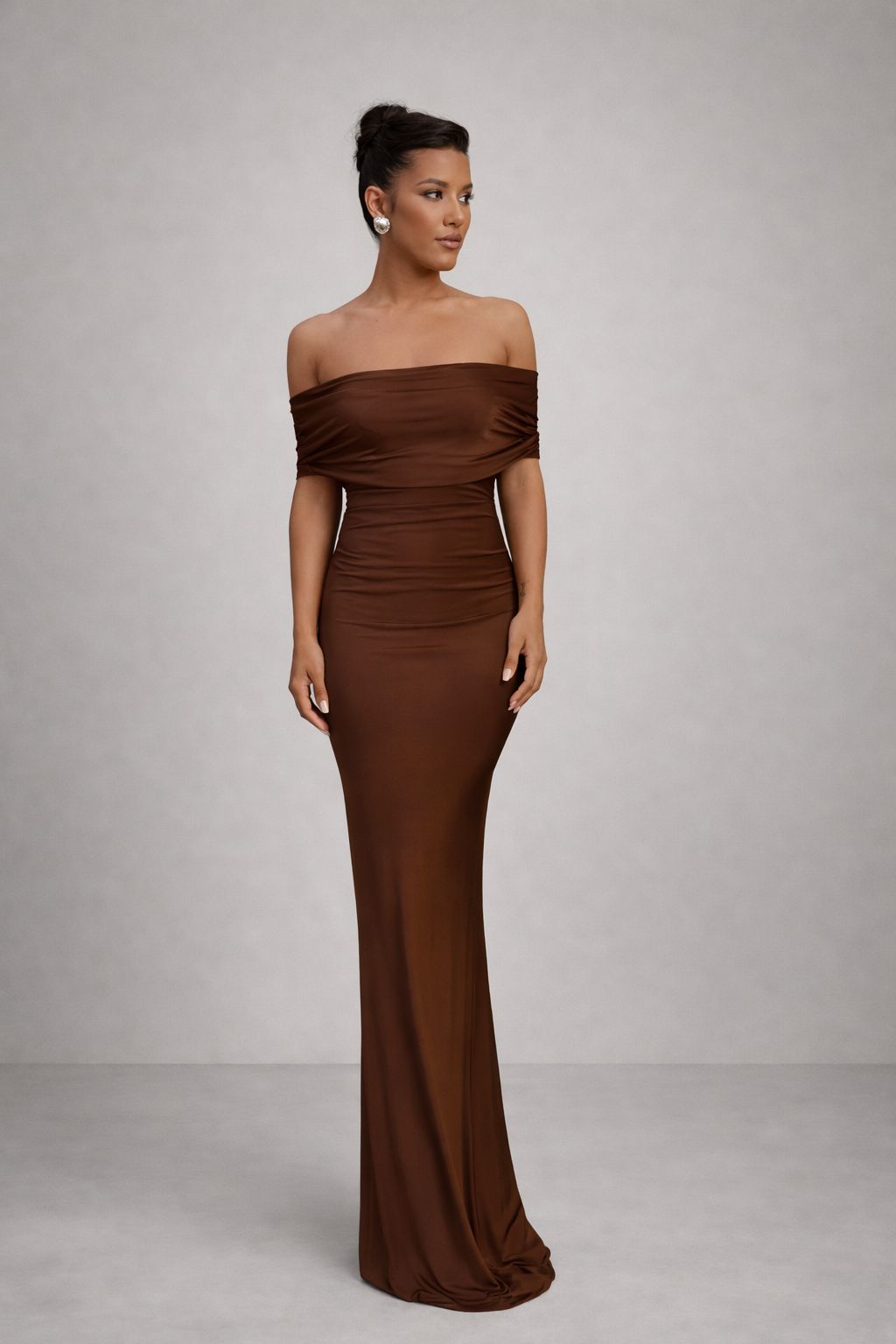Woman wearing a brown off-shoulder gown against a gray background