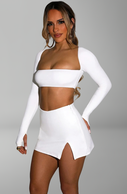 long-sleeve bandeau crop top and mini skirt with side slit for sexy nightlife and party looks.