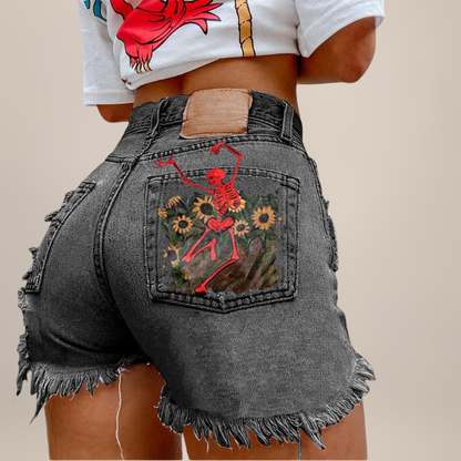 Person wearing gray denim shorts with a red skeleton design on the back pocket against a beige background