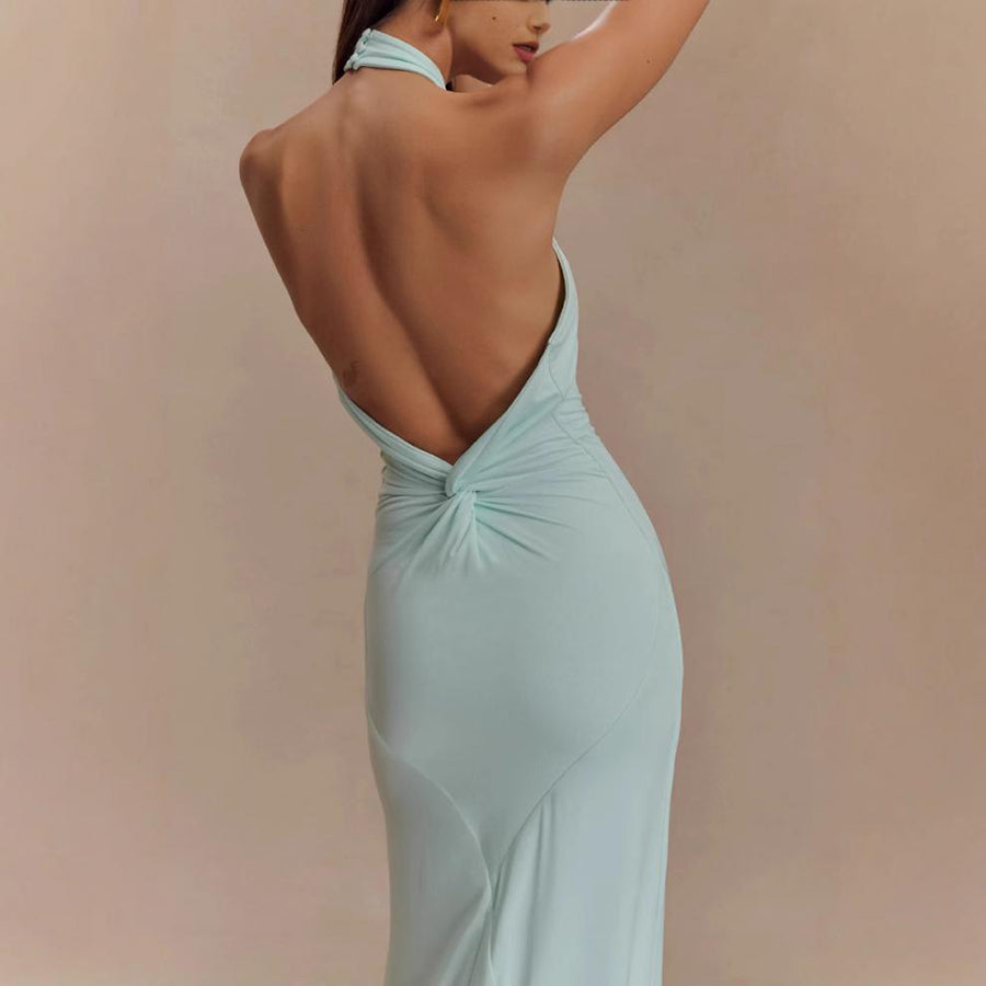 Model wearing a backless halter dress