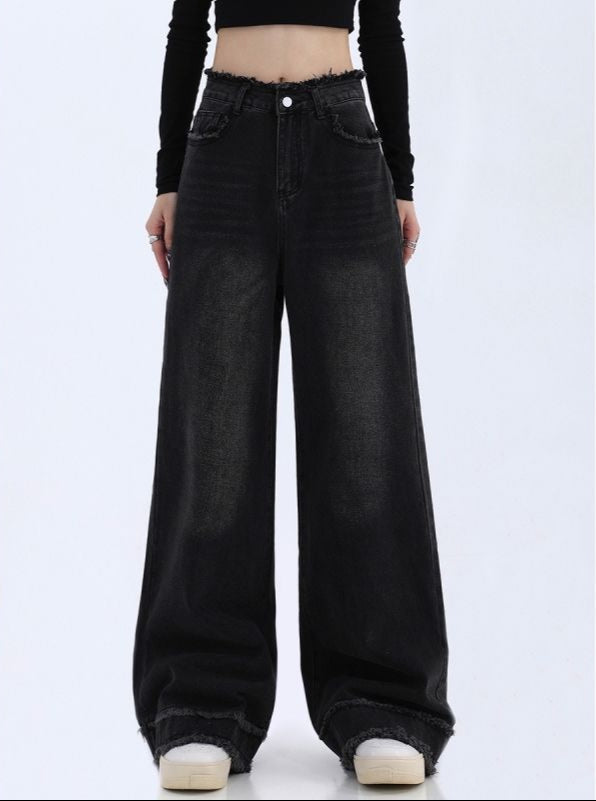 Black wide-leg jeans worn by a person on a white background