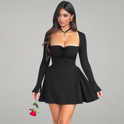 Woman wearing a black dress holding a red rose against a gray background