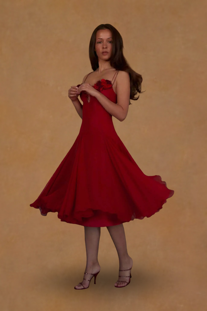 Woman wearing a red dress against a beige background