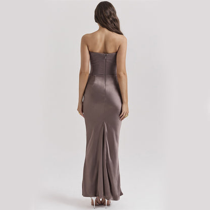 Woman wearing a strapless, floor-length metallic dress on a plain background