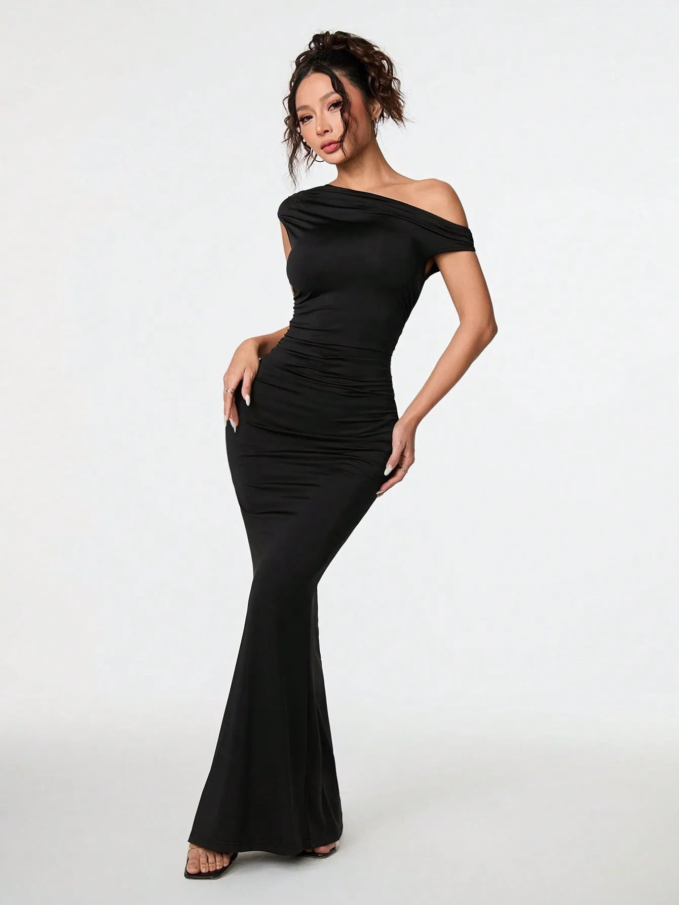 Woman wearing a black off-shoulder gown on a white background
