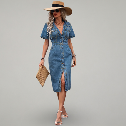 Woman wearing a denim dress with a hat and sunglasses on a gray background