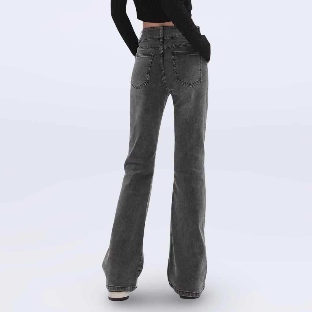 Gray flared jeans worn by a person on a white background